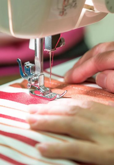 tailor-working-on-sewing-machine-close-up_t20_yRYdgL